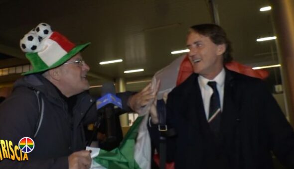 Enrico Lucci con la bandiera tricolore accoglie a Fiumicino gli Azzurri 